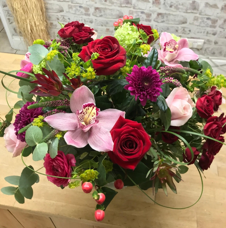 Deluxe red and pink hand tied bouquet in an included fishbowl vase.