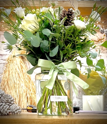 Florists choice of winter white flowers and greenery in an included eco vase.