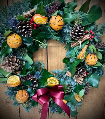 15” Spruce door wreath with dried fruit, blue thistle, berries and skimmia.