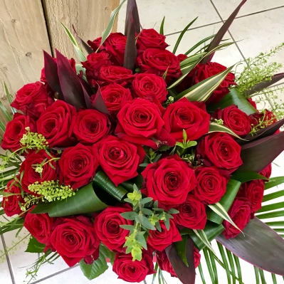Stunning 48 red roses hand tied bouquet in a large eco glass vase, these really make a statement!
