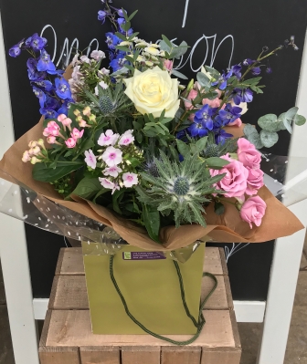 Country garden hand tied bouquet in water in a gift bag
