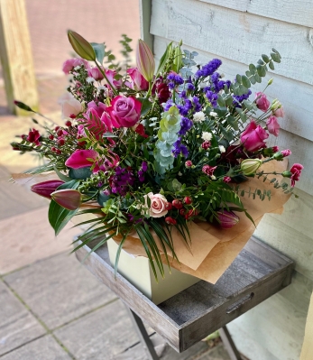 Deluxe jewel coloured hand tied bouquet presented in a gift box in water.