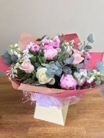 Hand tied bouquet presented in a gift box in water.