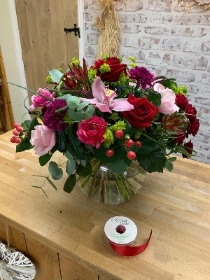 Deluxe red and pink hand tied bouquet in an included fishbowl vase.