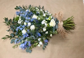 Blue and ivory tied spray with a natural raffia bow.