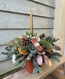 Festive candle arrangement in a terracotta pot.