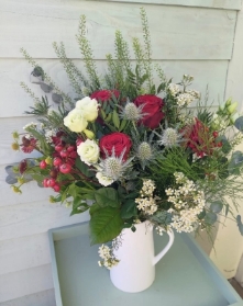 Hand tied bouquet in an included ceramic jug.