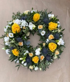 Pretty yellow and white wreath with blue thistle.